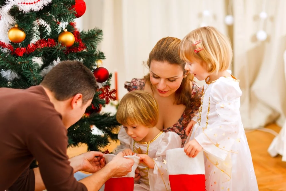 Julehygge med forældre og 2 børn ved juletræet